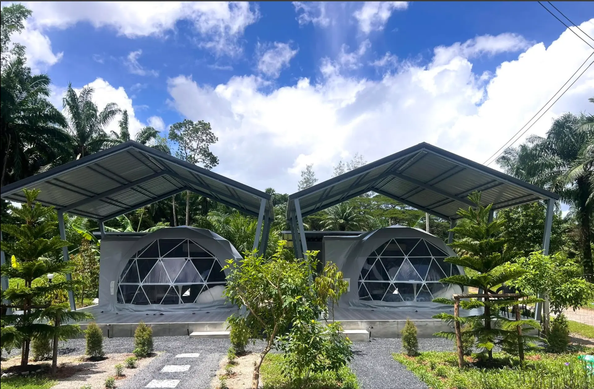 Two geodesic domes beneath a bright blue sky at Wanasa Cafe and Glamping